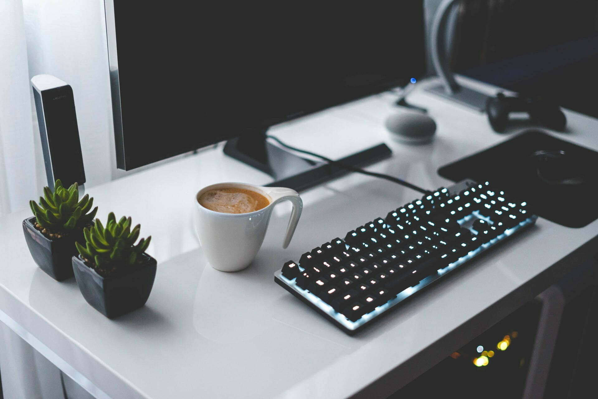 a keyboard and coffee mug on a desk