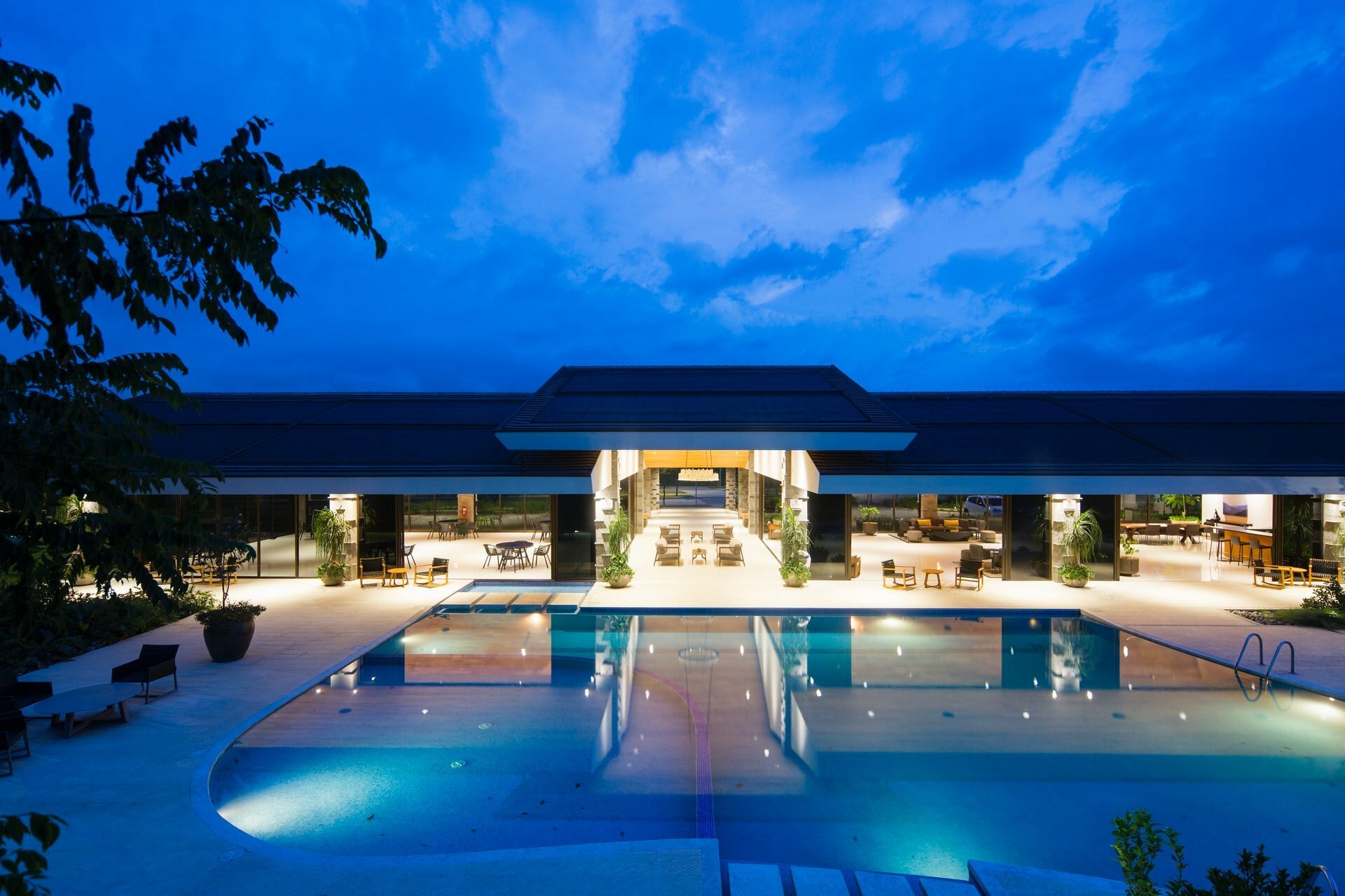 a swimming pool in front of a house at night